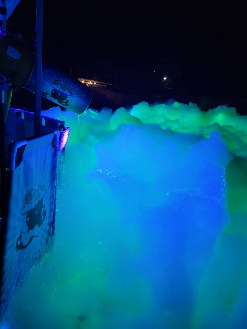 Foamsational Fun foam cannon producing blue and green glowing foam after dark
