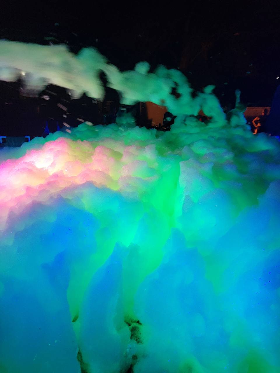 Guests celebrating at a Foamsational Fun Glow Foam Night Party after dark